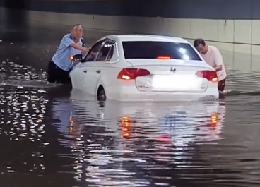 驰赢策略 洛阳大雨致司机被困 交警挽起裤子帮忙推车